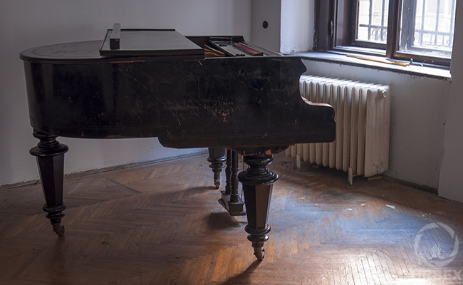 a piano in an abandoned chateau